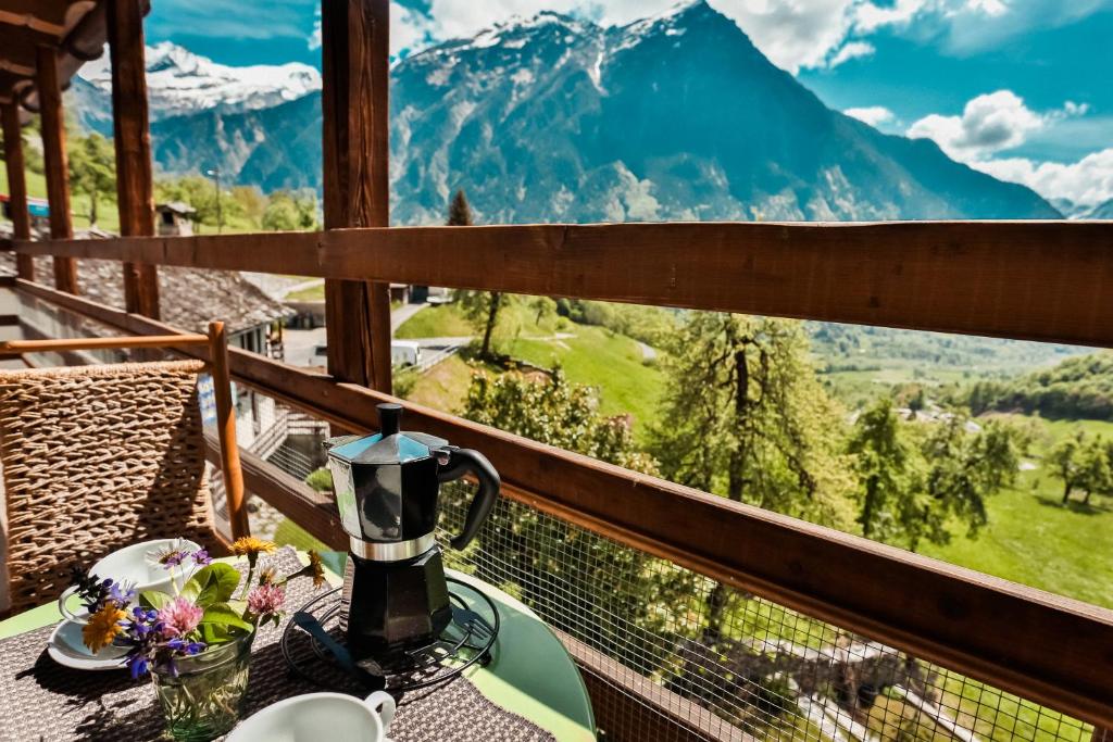 a coffee maker on a table on a balcony with mountains at Attico Adula in Castro