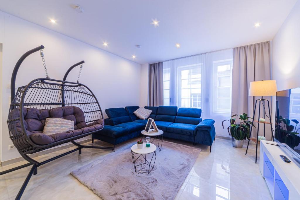 ein Wohnzimmer mit einer blauen Couch und einer Schaukel in der Unterkunft Lit Living: Luxury - Box Spring - Zwischen MA und HD - Netflix - 8 Personen in Ladenburg