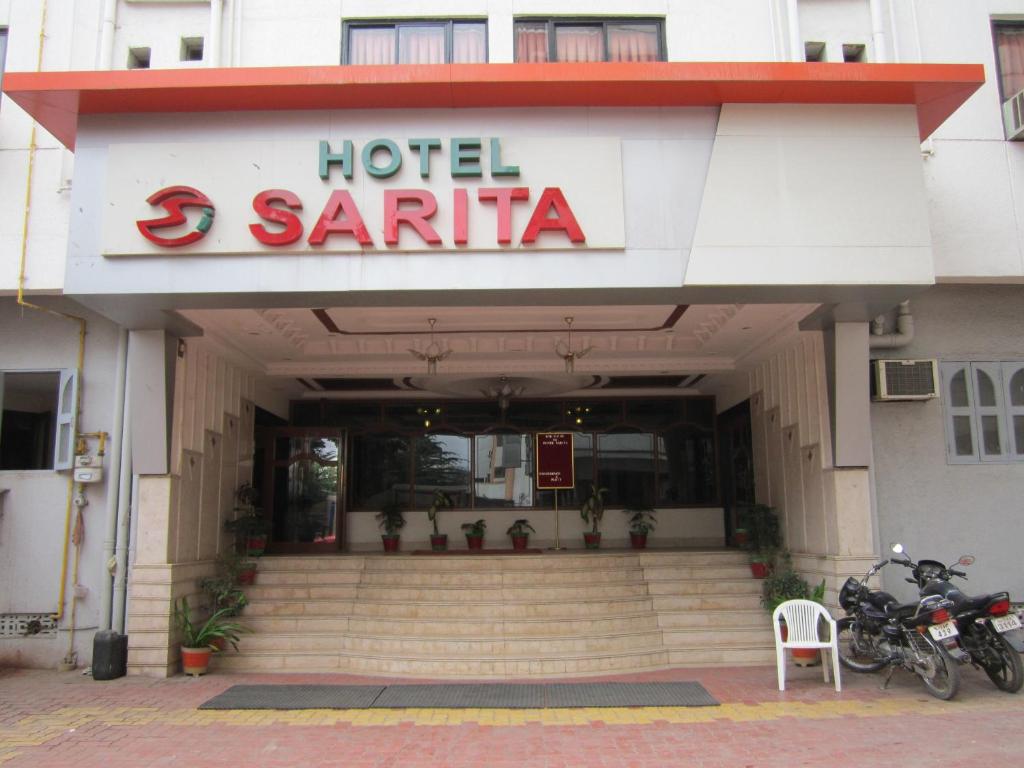 ein Hotel Santinia mit einem Motorrad, das draußen geparkt ist in der Unterkunft Hotel Sarita in Surat