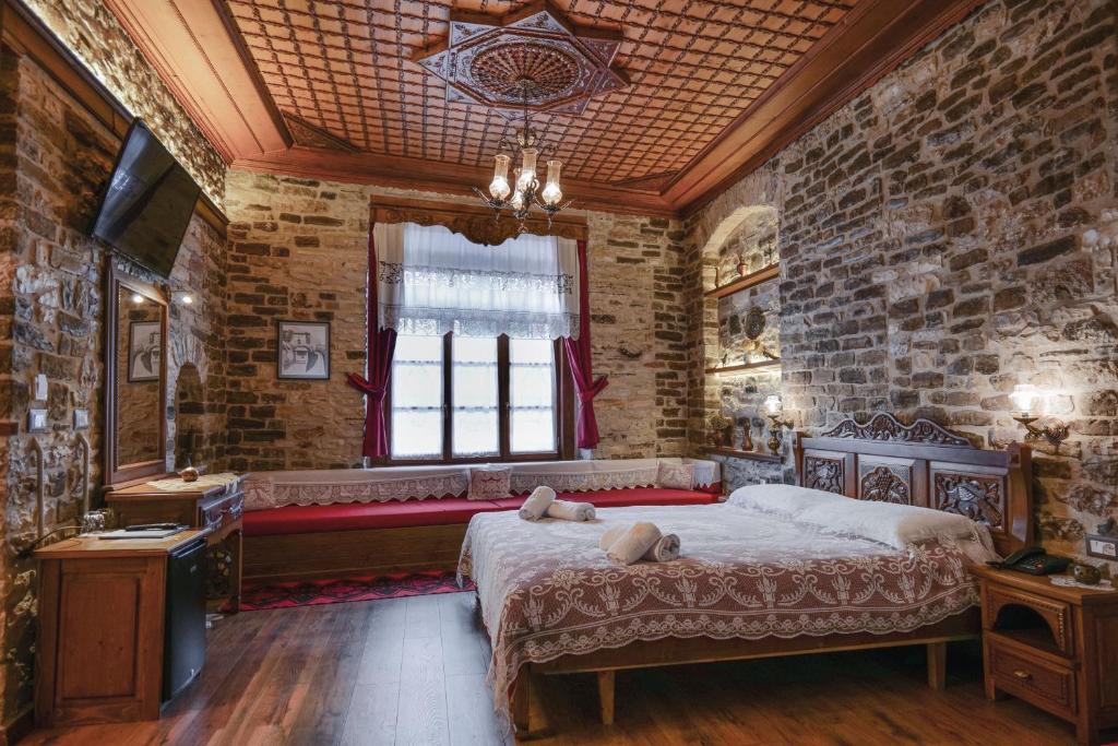 een slaapkamer met een groot bed en een raam bij Hotel Bineri in Gjirokastër