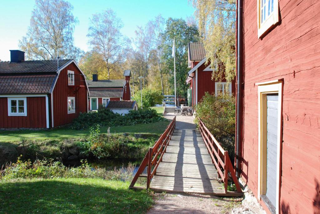 un puente de madera junto a un edificio rojo en STF Korrö B&B en Linneryd