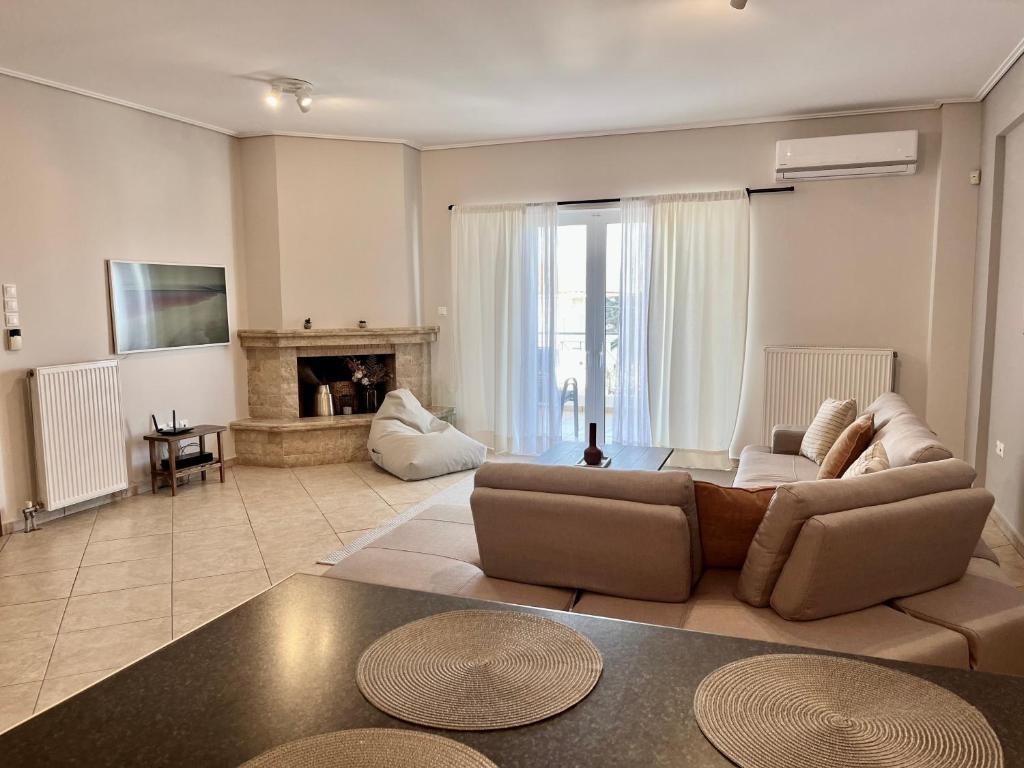 a living room with a couch and a fireplace at Hector Apartment Airport by Airstay in Spata