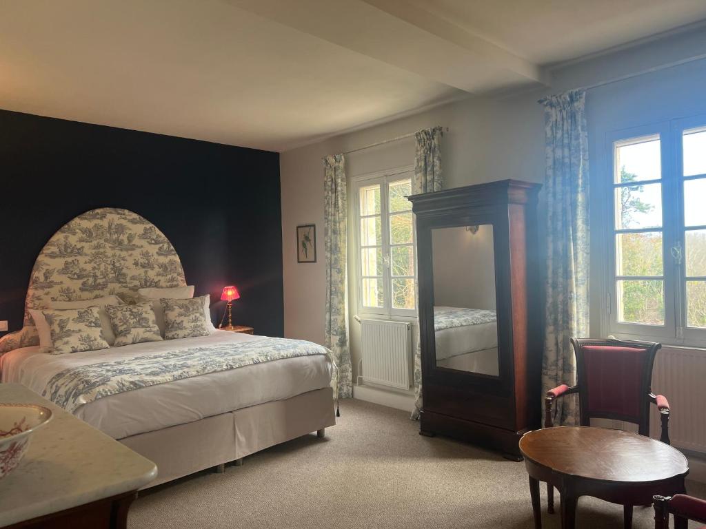 a bedroom with a bed and a table and window at Manoir du Bois Mignon in Le Fleix