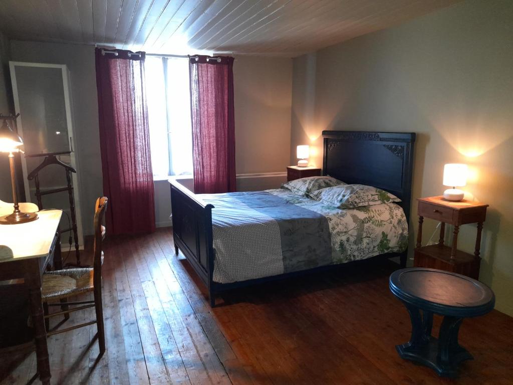 a bedroom with a bed and a table and two lamps at Maison entière avec petite cour intérieure. in Monthureux-sur-Saône