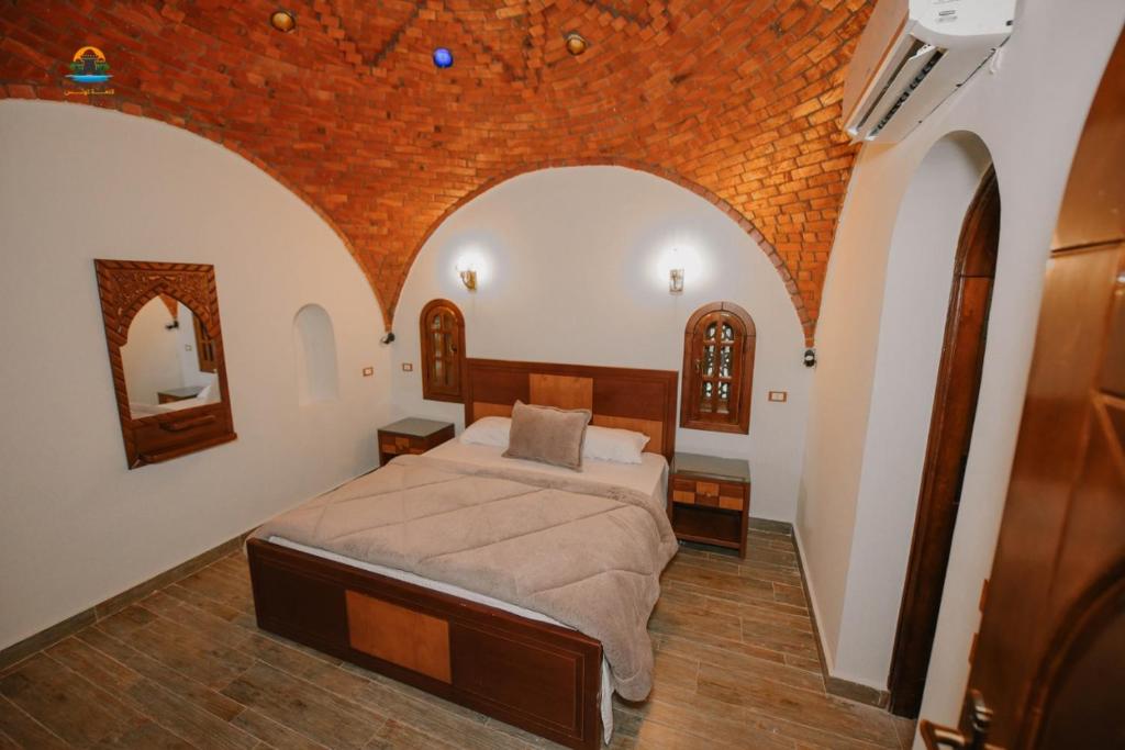 Tunisia Castle Motel في الفيوم: غرفة نوم بسرير في غرفة مقوس