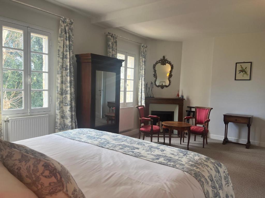 a bedroom with a bed and a table and chairs at Manoir du Bois Mignon in Le Fleix