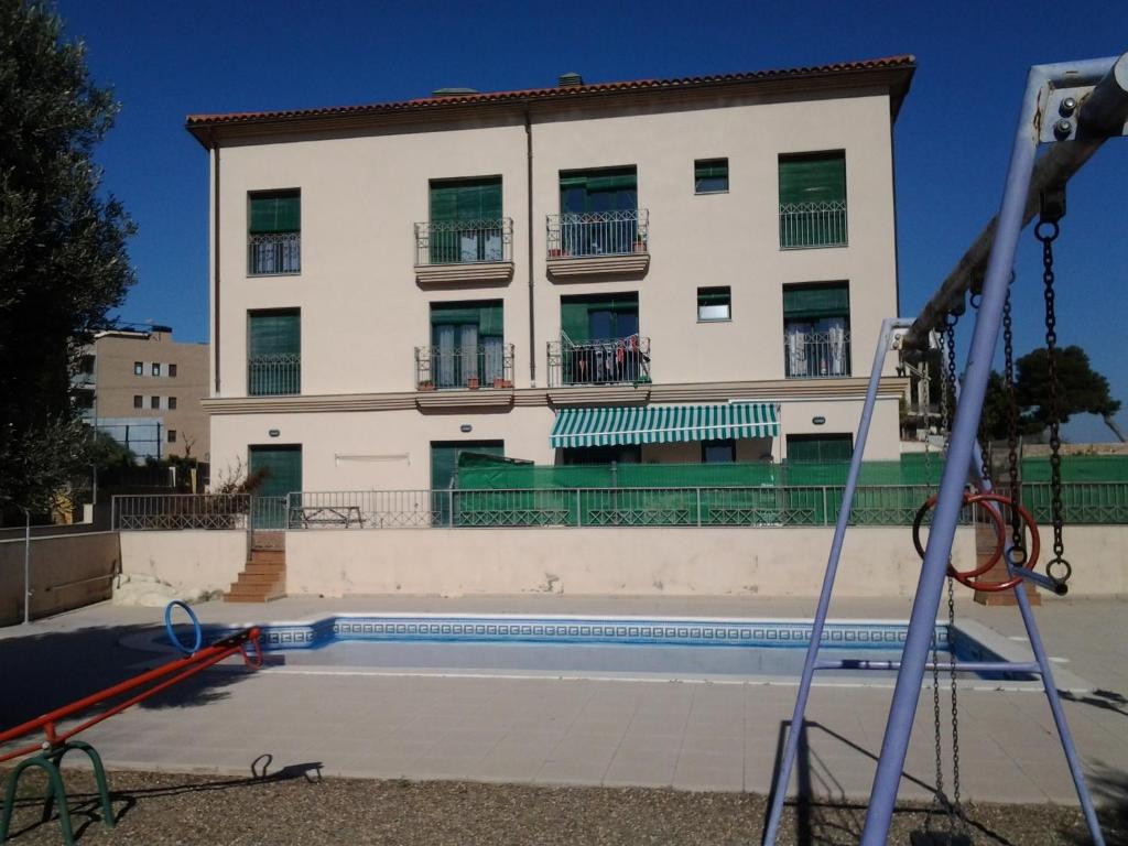 um edifício com piscina em frente a um edifício em Torredembarra em Torredembarra