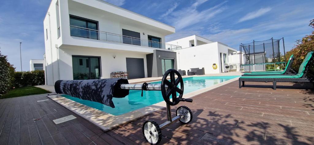 um canhão em frente a uma casa com uma piscina em Lara Sweet Home em Sobral do Parelhão