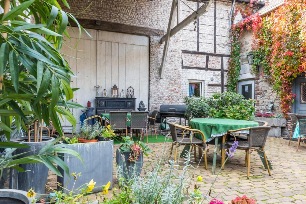 un patio con mesa, sillas y plantas en Stay rooms, en Dalhem