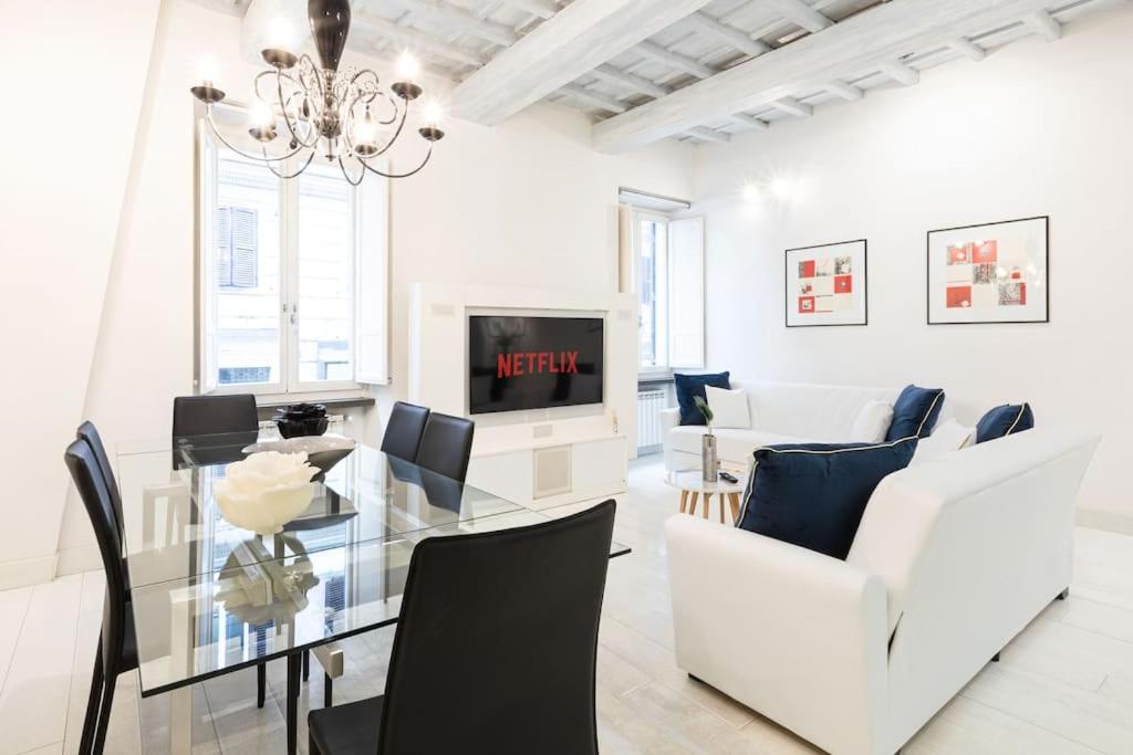 een witte woonkamer met een glazen tafel en witte stoelen bij Manara 57 Dream Apartment Trastevere in Rome