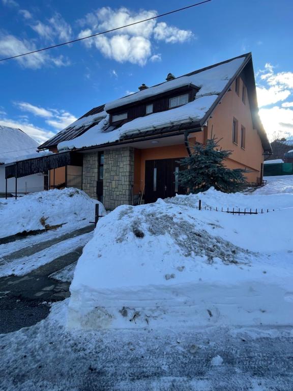 una casa con un montón de nieve delante de ella en Apartmán Králiky, en Králiky