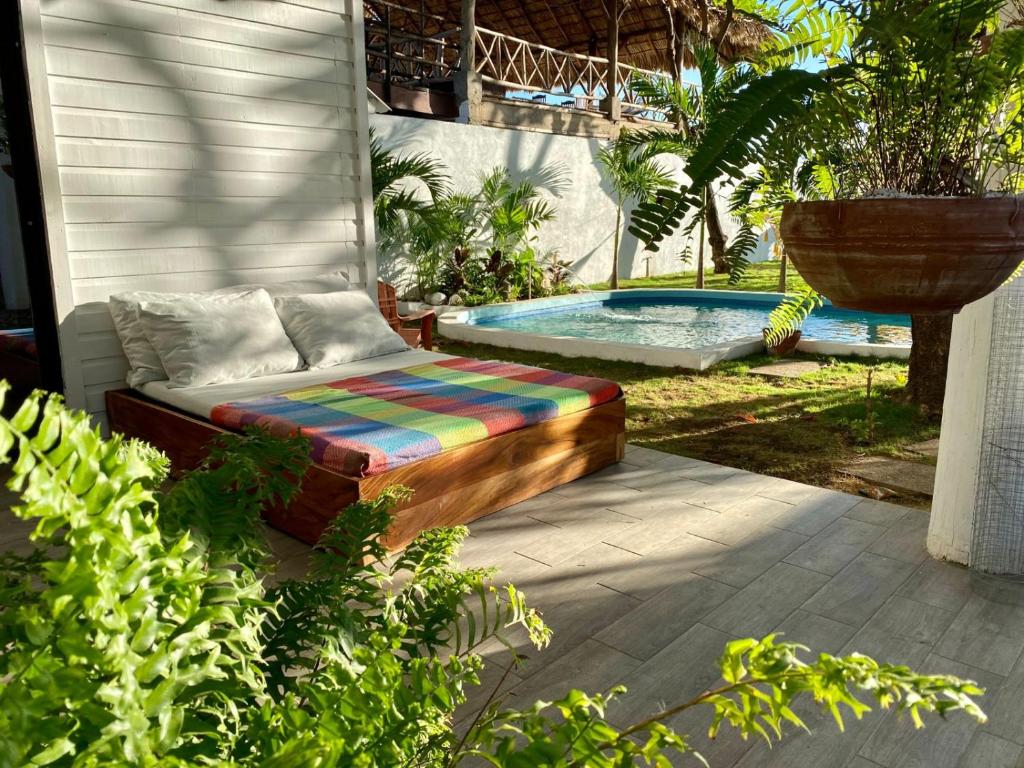 ławka siedząca na patio obok basenu w obiekcie JAKES ON THE BEACH w mieście Las Peñitas