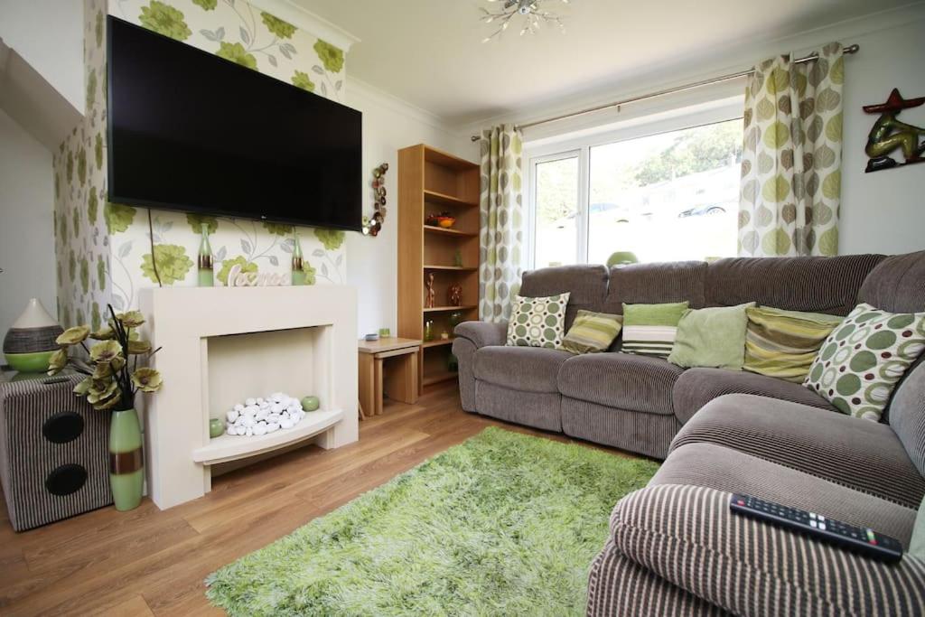 ein Wohnzimmer mit einem Sofa und einem Kamin in der Unterkunft 3 Bedroom family home Newport, Located next to M4 in Newport