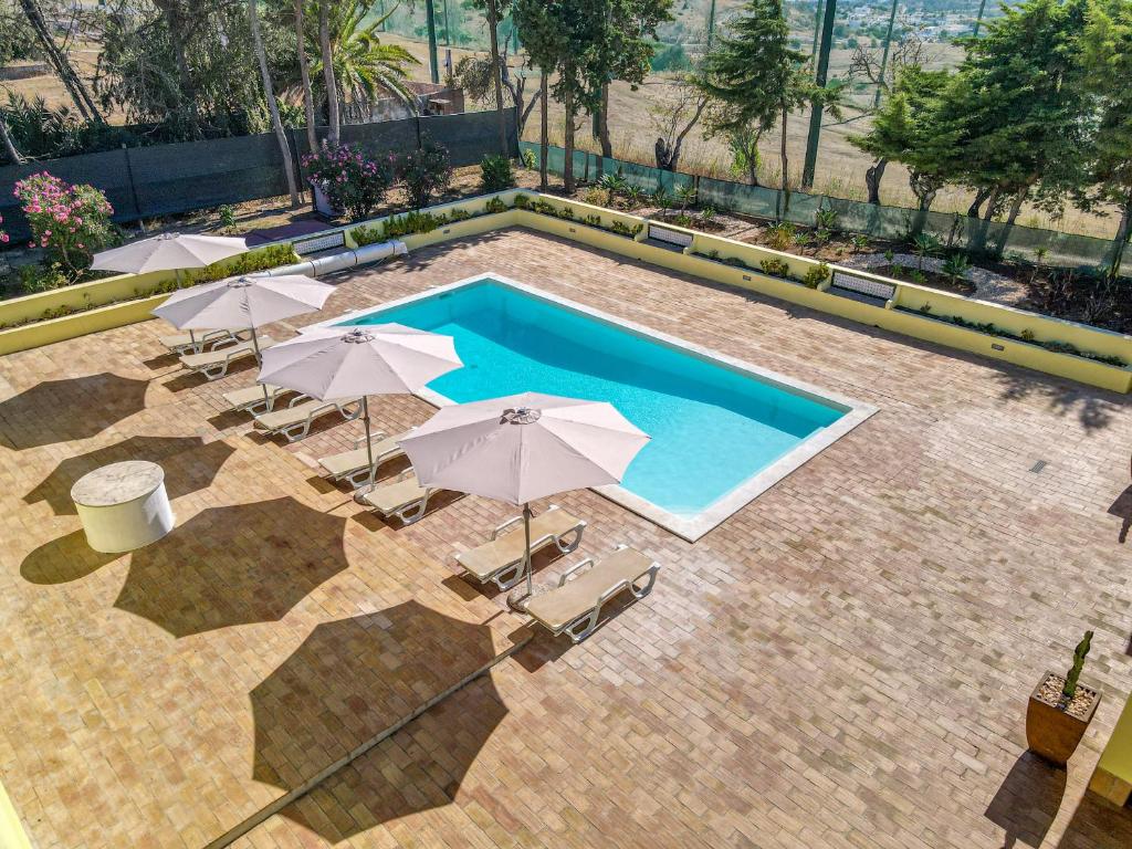 a swimming pool with umbrellas and chairs and a swimming pool at Casa Dean by Algarve Golden Properties in Lagos