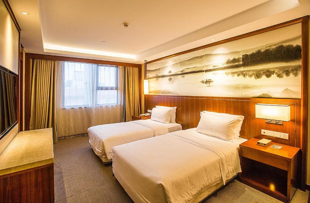 南京的住宿－南京新街口王府大街亚朵酒店，酒店客房设有两张床,墙上挂有绘画作品
