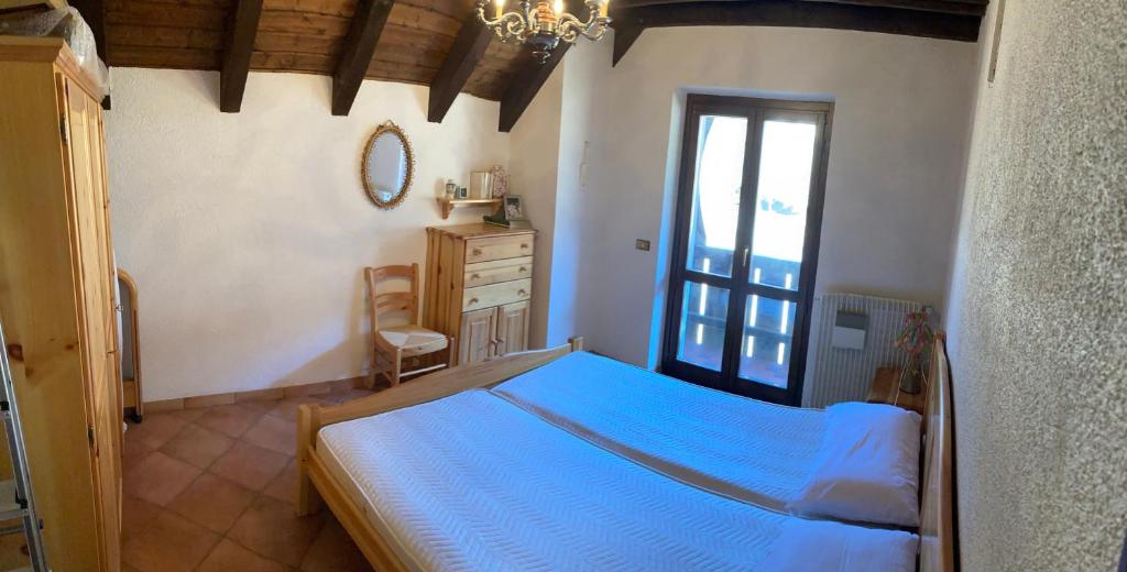 1 dormitorio con 1 cama, vestidor y ventana en Casa vacanze Ravascletto, en Ravascletto