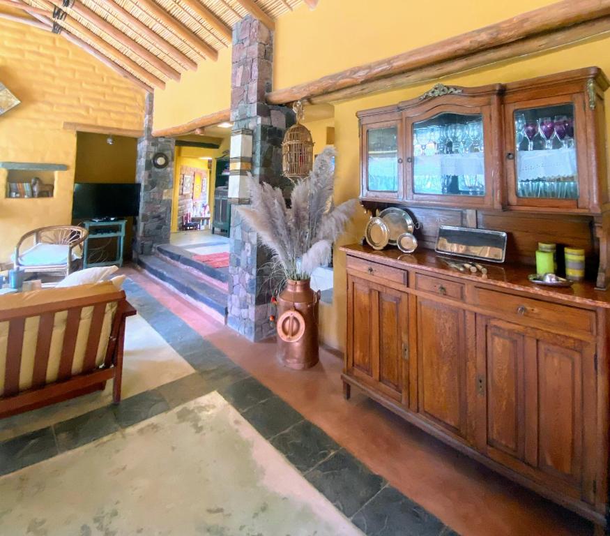 a living room with a large wooden cabinet and a fireplace at Finca La Candelaria in Maimará