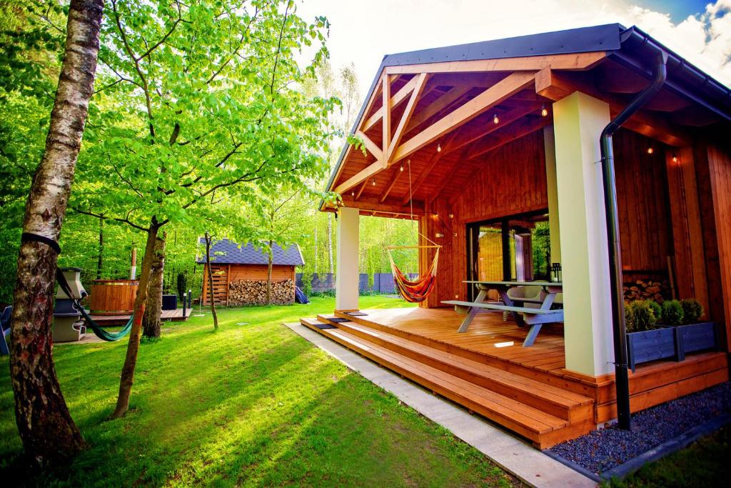 Casa pequeña con terraza de madera en un patio en Winiec Family Houses, en Winiec