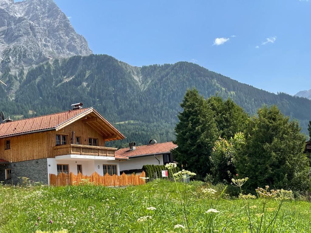 a house in a field with mountains in the background at Haus Sieben Zwerge in Ehrwald