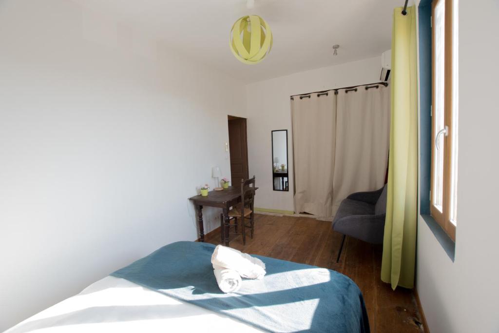 a bedroom with a bed and a desk in a room at Ateliers, Terrasse - Parking - Clim in Arles