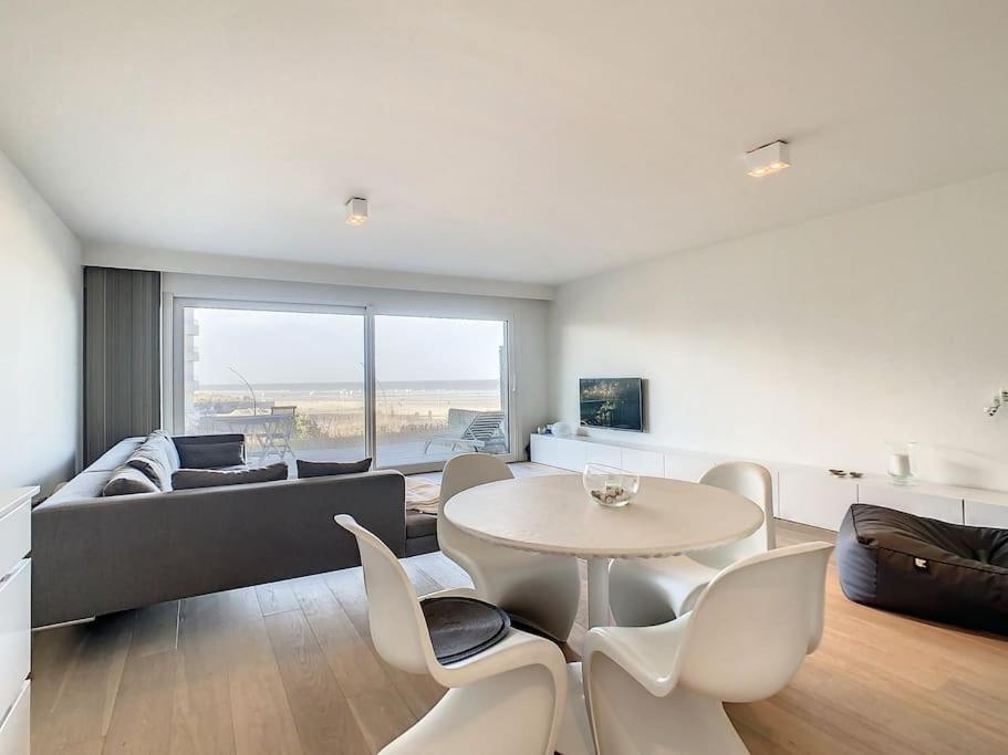 a living room with a couch and a table and chairs at Appartement 'Witte Berg' De Panne in De Panne