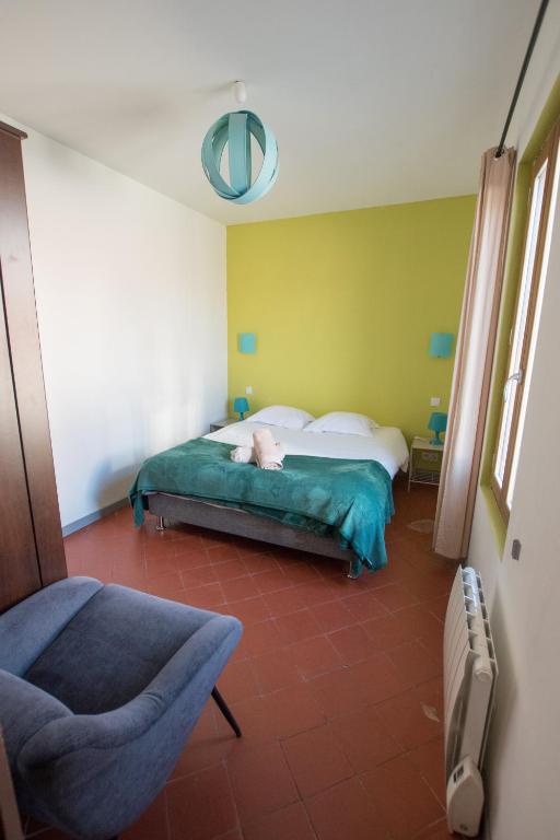 a bedroom with a bed and a chair in it at Ateliers, Terrasse - Parking - Clim in Arles