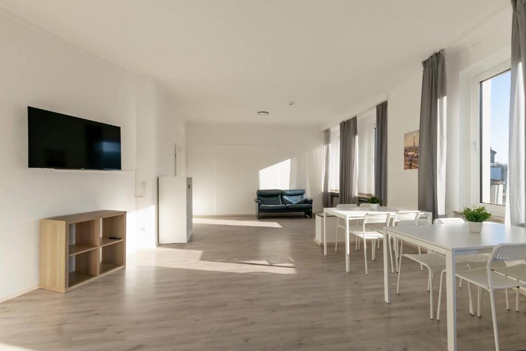 sala de estar con mesas blancas y TV de pantalla plana en T&K Apartments-Duisburg 4 Zimmer Apartment, en Duisburg