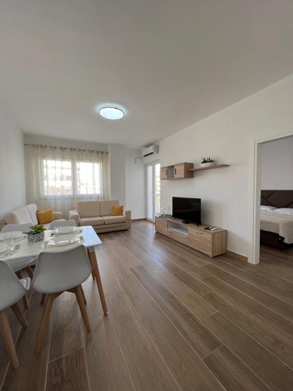 ein großes Wohnzimmer mit einem Tisch und einem Sofa in der Unterkunft Waterfront Apartments in Durrës