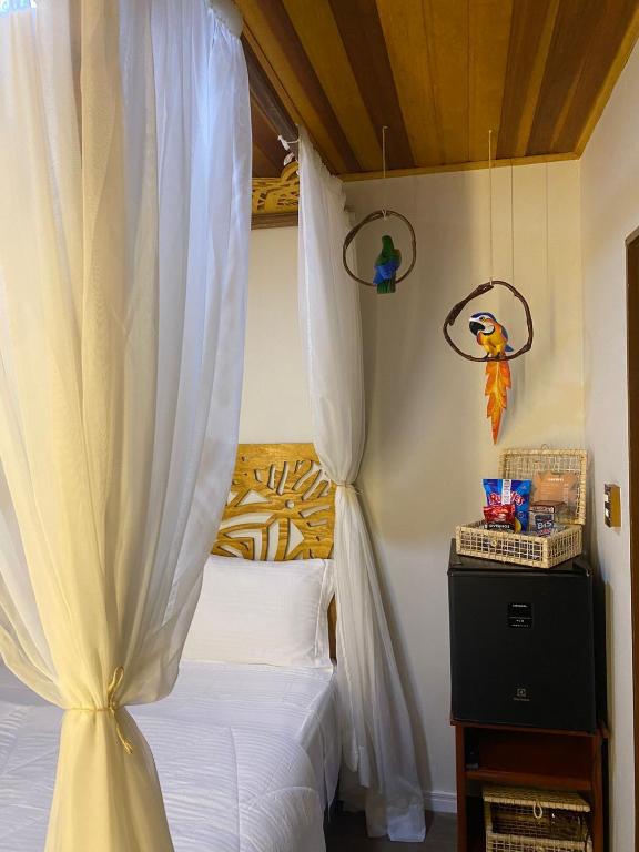 a bedroom with a bed with a white canopy at Pousada Village Mel in Ilha do Mel