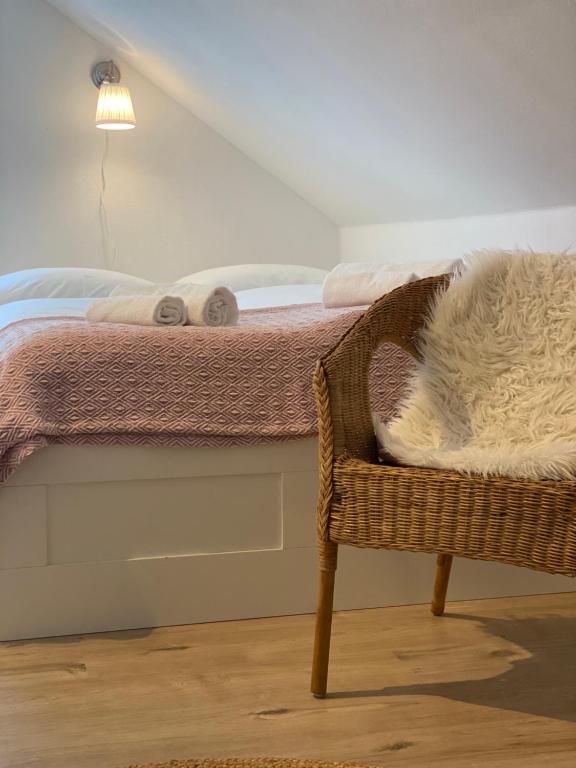 un gato acostado en una cama junto a una silla en Appartement Am Waldweg en Achern
