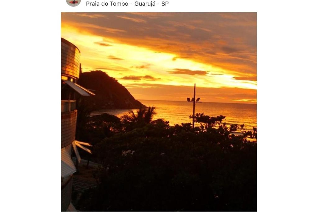 una foto di un tramonto sull'oceano di 12F- Vista Linda Pé na areia Guarujá Praia do Tombo+2dorm c/ar cond+2WC+1vaga+cozinha completa frente ao mar ( INTERNET RÁPIDA ) - Check-in às 13hs e Check-out até às 18hs a Guarujá