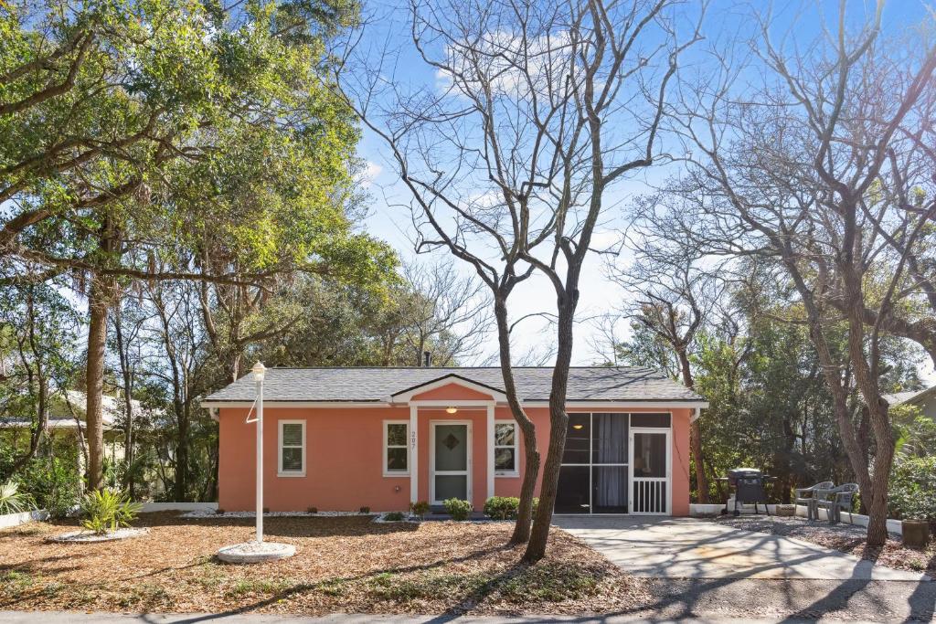 a small orange house with a tree in front of it at 207 W Cooper Coral Cassita Central Location in Folly Beach
