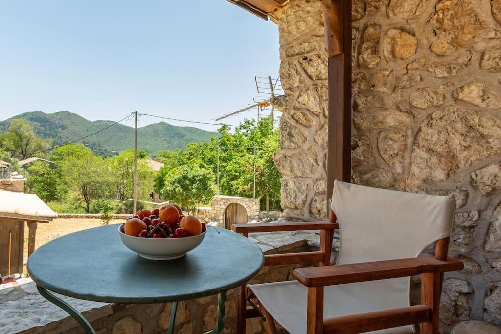 un bol de fruta sentado en una mesa en un patio en PONTZOS - Traditional stonehouse in the heart of Lefkada en Alexandros