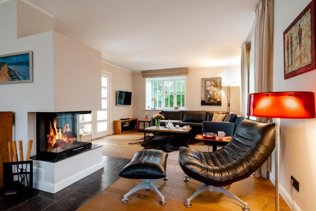 a living room with a couch and a fireplace at Seaside Lodge Sylt in Westerland
