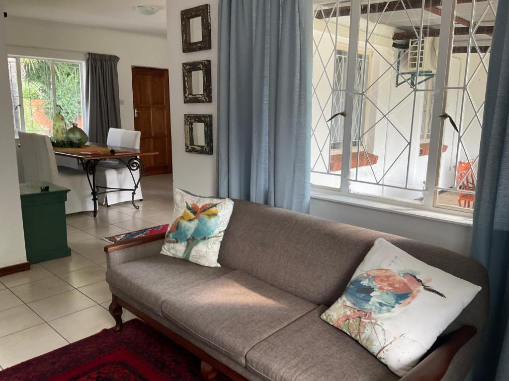 a living room with a couch and a window at Vintage Palm II in Gaborone