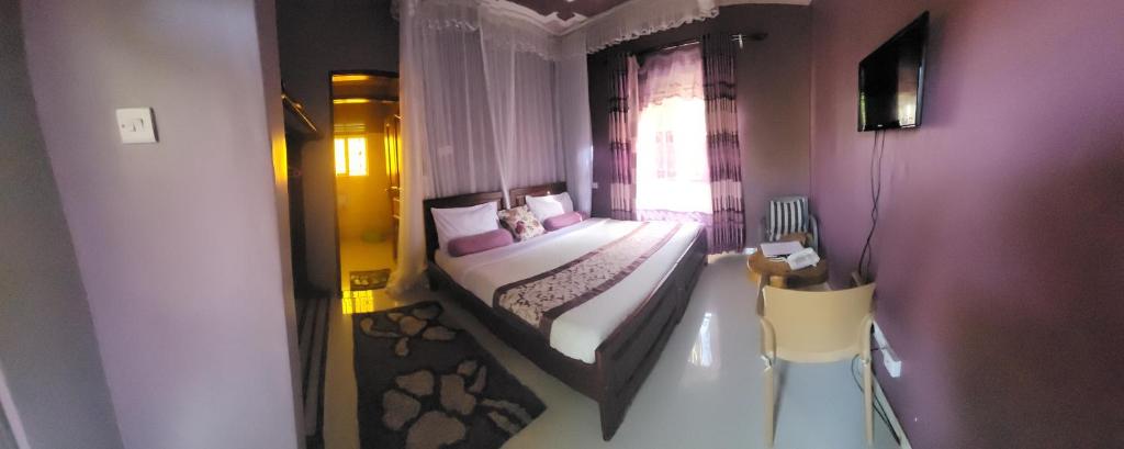 a small bedroom with a bed and a window at Philo Leisure Gardens in Kalangala