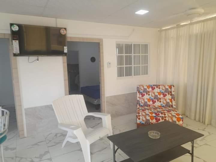 sala de estar con TV, silla y mesa en DEPARTAMENTO-MANTA, Playa Murciélago, en Manta