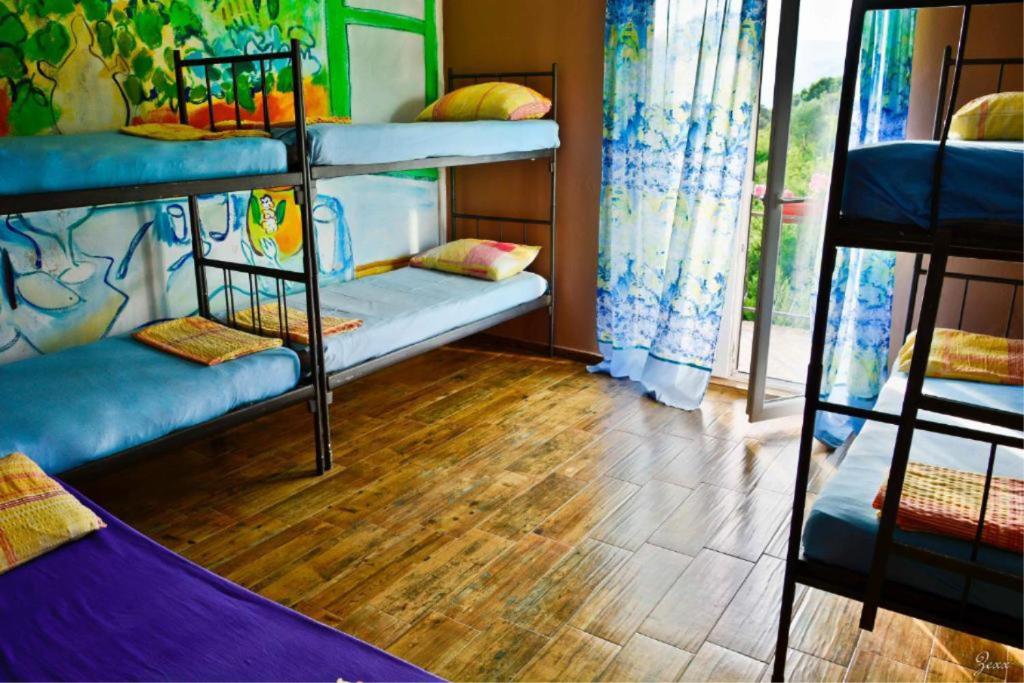 a room with three bunk beds and a wooden floor at Hostel Anton in Tivat