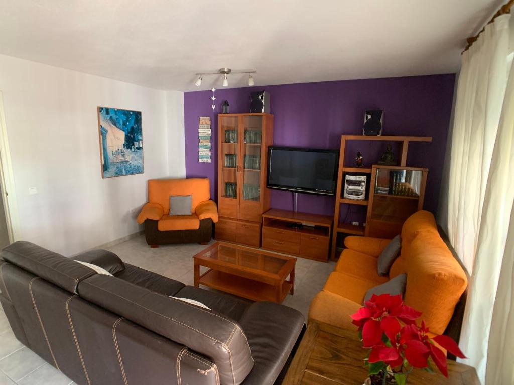 a living room with a couch and a tv at Apartamento - La Cala in Cala del Moral