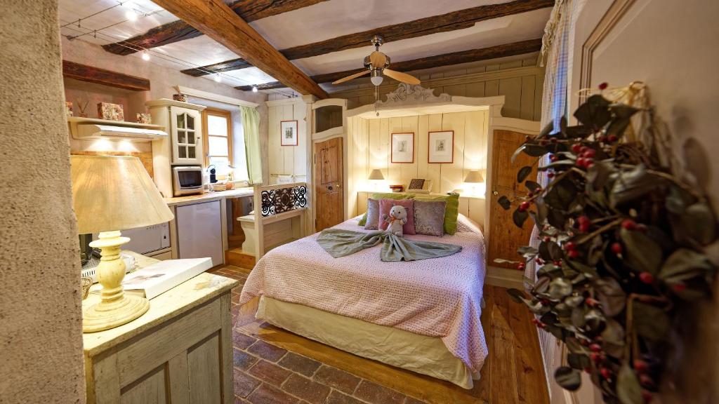 ein kleines Schlafzimmer mit einem Bett und einer Küche in der Unterkunft Remparts de Riquewihr - Refuge du Lutin - Studio in Riquewihr