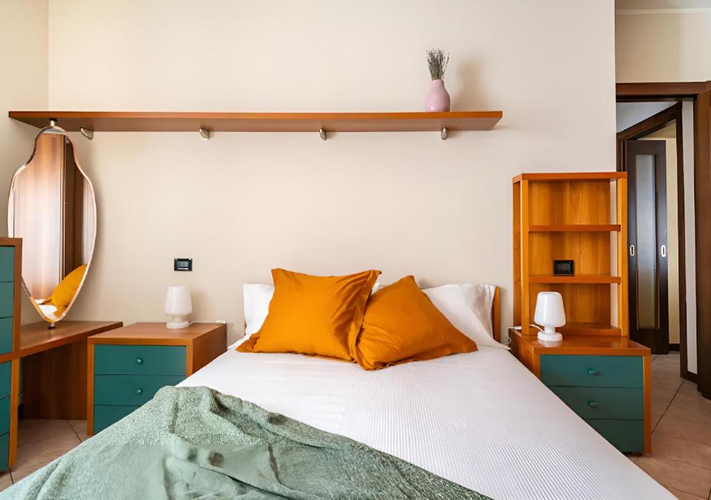 1 dormitorio con 1 cama con almohadas de color naranja en LAGO D'ISEO - Ampio alloggio in centro storico en Pisogne