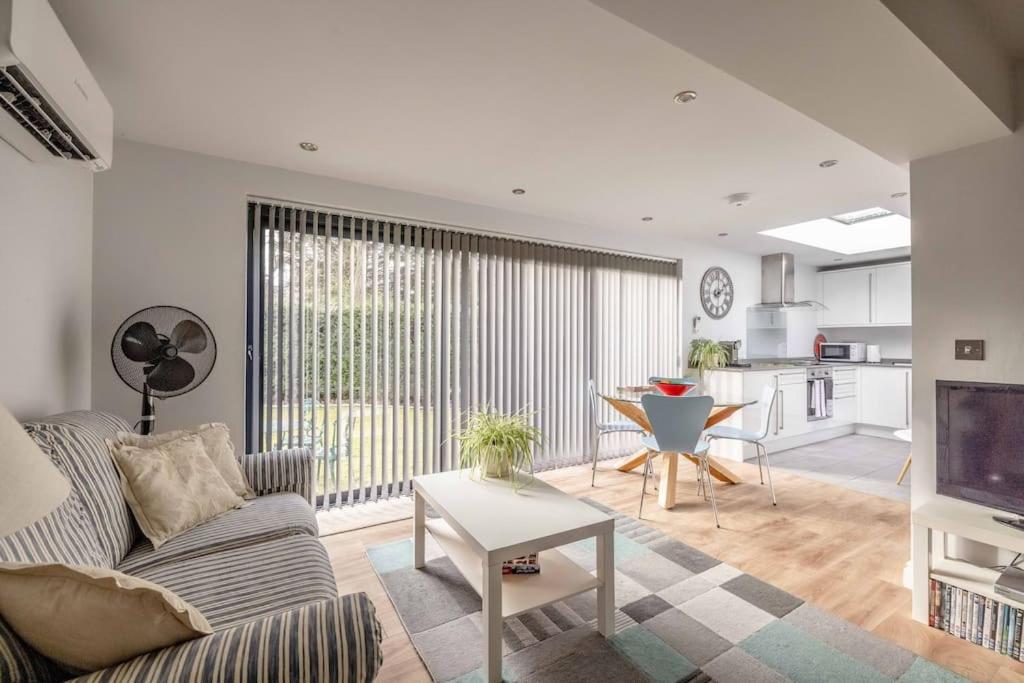 a living room with a couch and a table at Cosy Home Near Sunningdale/Ascot/Wentworth Golf Club in Sunninghill