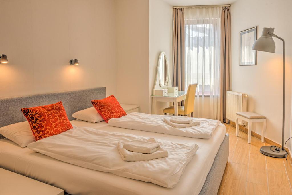1 dormitorio con 2 camas y almohadas de color naranja y blanco en City Center Apartments, en Budapest