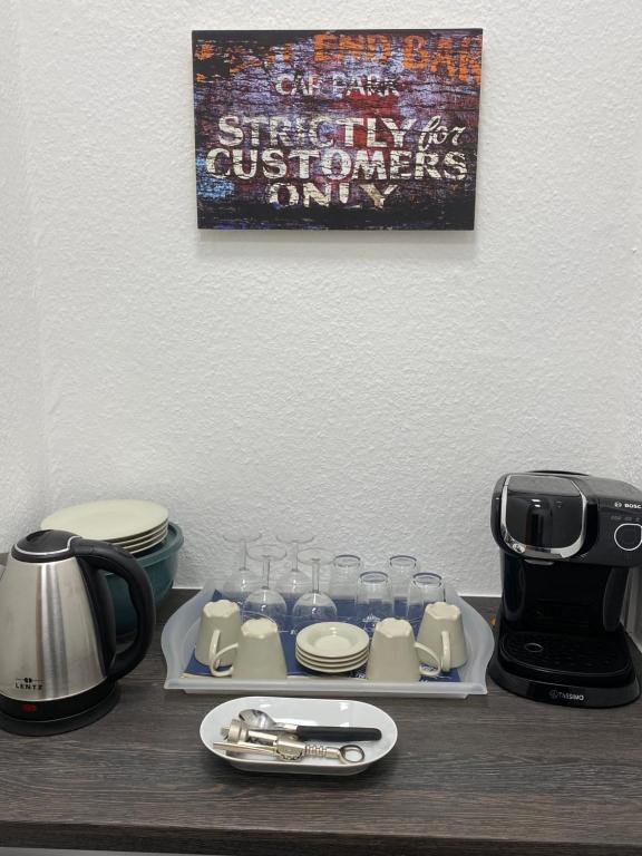 a table with glasses and a coffee maker and a toaster at Pension Villa Ostseetraum in Warnemünde