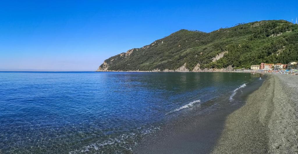 una playa de arena negra y agua azul en 097 - Casa Stella a Riva Trigoso, 300 metri da mare e spiaggia, POSTO AUTO PRIVATO GRATIS, en Sestri Levante
