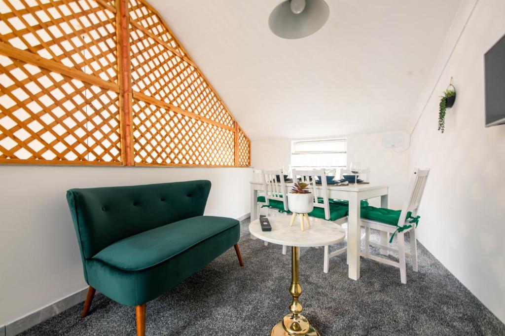 een woonkamer met een groene stoel en een tafel bij Stylish Holiday Home Groups-Families 3M in Londen