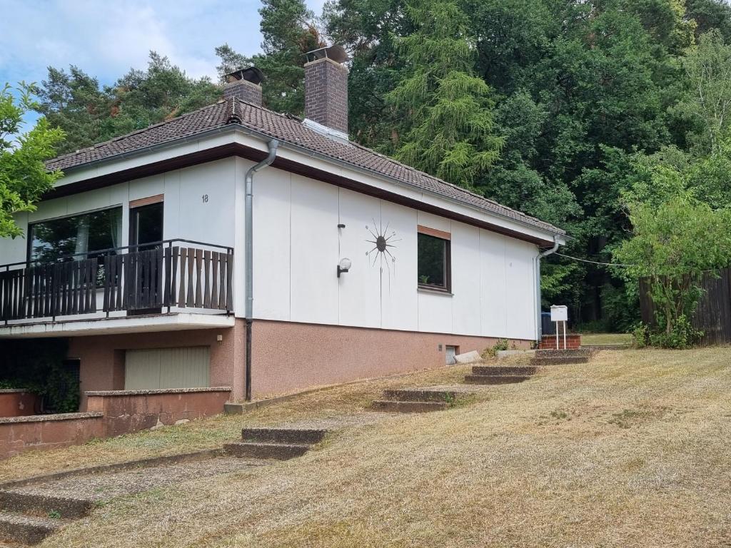 een wit huis met een veranda en een balkon bij Ferienhaus Magnolie in Großheubach