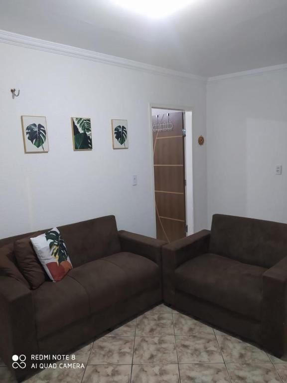 uma sala de estar com dois sofás castanhos num quarto em Apartamento no centro de Vicosa-ce em Viçosa do Ceará