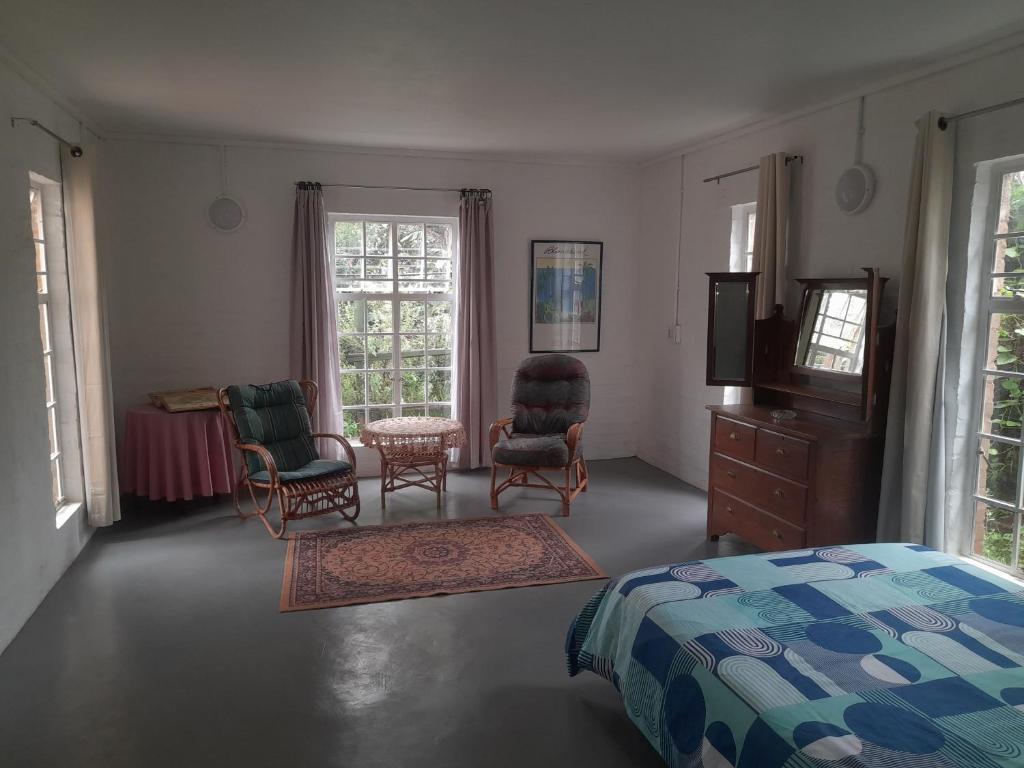 a bedroom with a bed and two chairs and a tv at Oorslaap in Florida