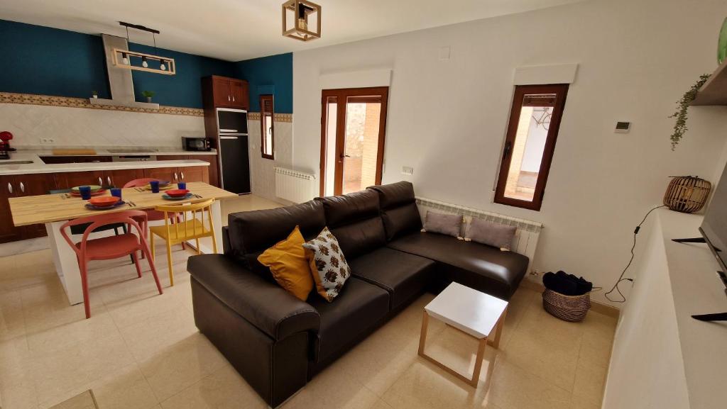 sala de estar con sofá de cuero y cocina en El Callejón, en Vara de Rey